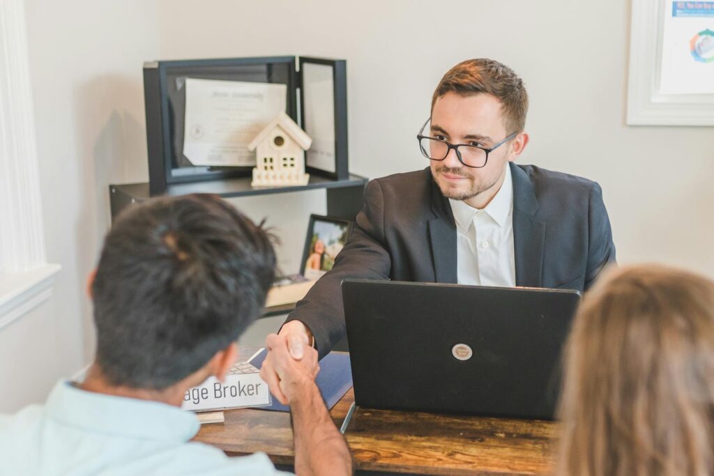 Business professionals in an office setting sealing a real estate deal through a handshake.