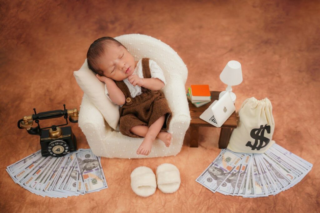 Newborn baby sleeps in tiny chair with money props. Placer son argent pour les nuls