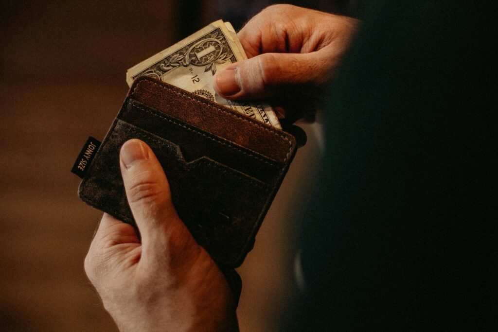 person getting 1 U.S. dollar banknote in wallet, Combien mettre de côté par mois
